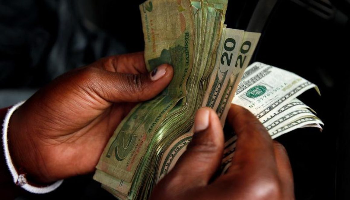 An illegal money changer counts dollar notes in Harare