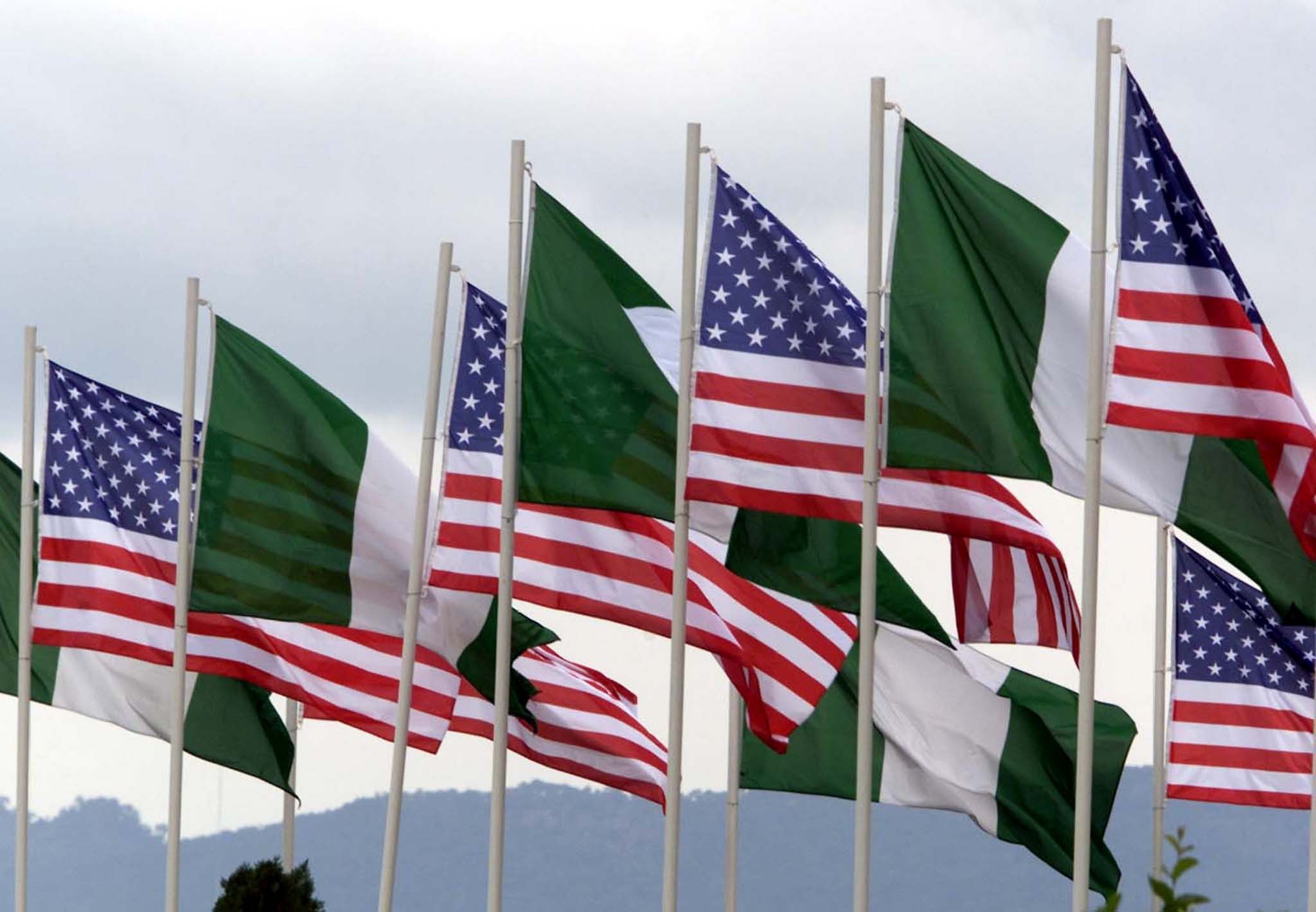 AMERICAN AND NIGERIAN FLAGS FLY NEXT TO EACH OTHER.