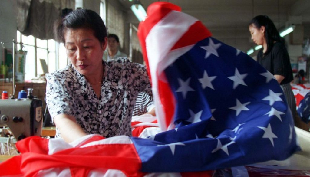 A seamstress at the Beijing Red Flag factory in Beijing sews together the red and white stripes of a..