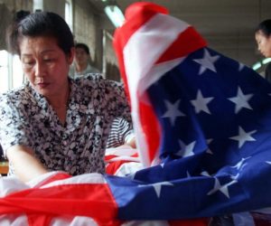 A seamstress at the Beijing Red Flag factory in Beijing sews together the red and white stripes of a..