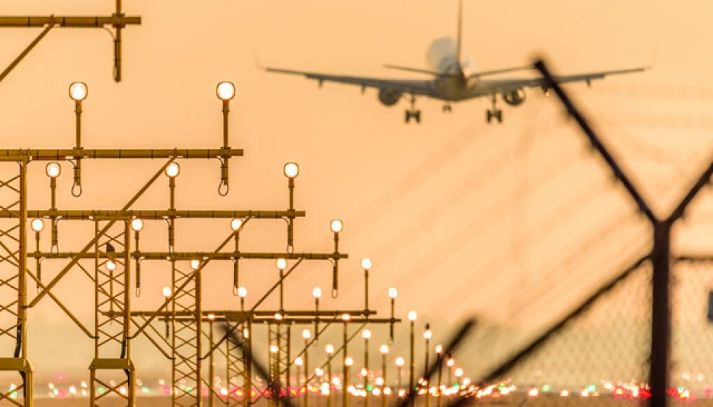 Airplane-or-aeroplane-landing-at-the-runway-during-sunset