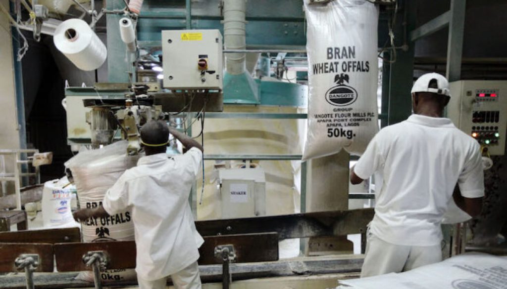 Workers operate a machine at the Dangote flour mill in Apapa district in Nigeria's commercial capital of Lagos
