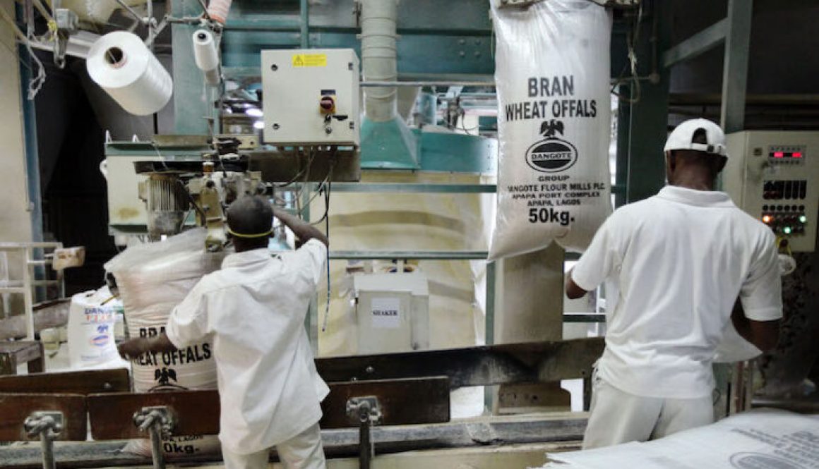 Workers operate a machine at the Dangote flour mill in Apapa district in Nigeria's commercial capital of Lagos