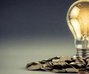 Light bulb and pile of coins with copy space