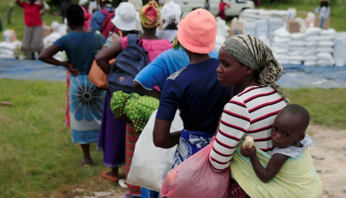 FILE PHOTO: Villagers queue to collect food aid distributed by the World Food Program (WFP) in rural Mudzi district